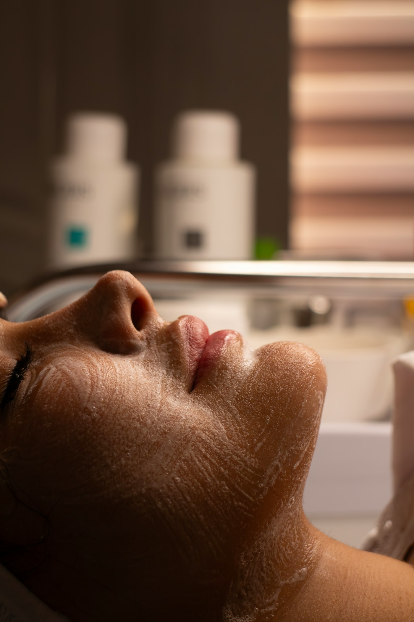 A client receiving a foaming facial skin treatment