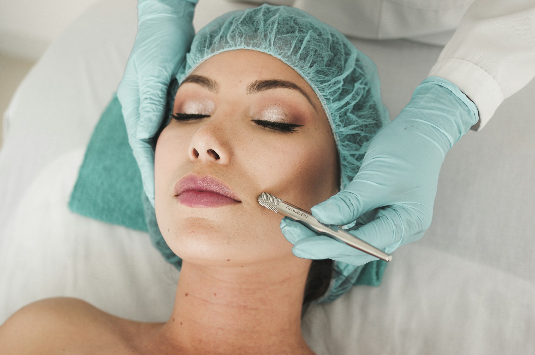 An esthetic professional providing a facial treatment in a treatment room